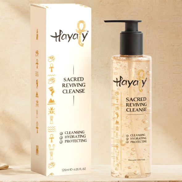 Hayaty Sacred Reviving Cleanse shown with its white and gold packaging box next to a clear pump bottle containing the liquid cleanser, set against a textured beige background